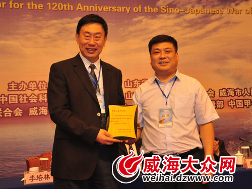 中国甲午战争博物院郭阳院长（右）向中国社会科学院赠送纪念牌